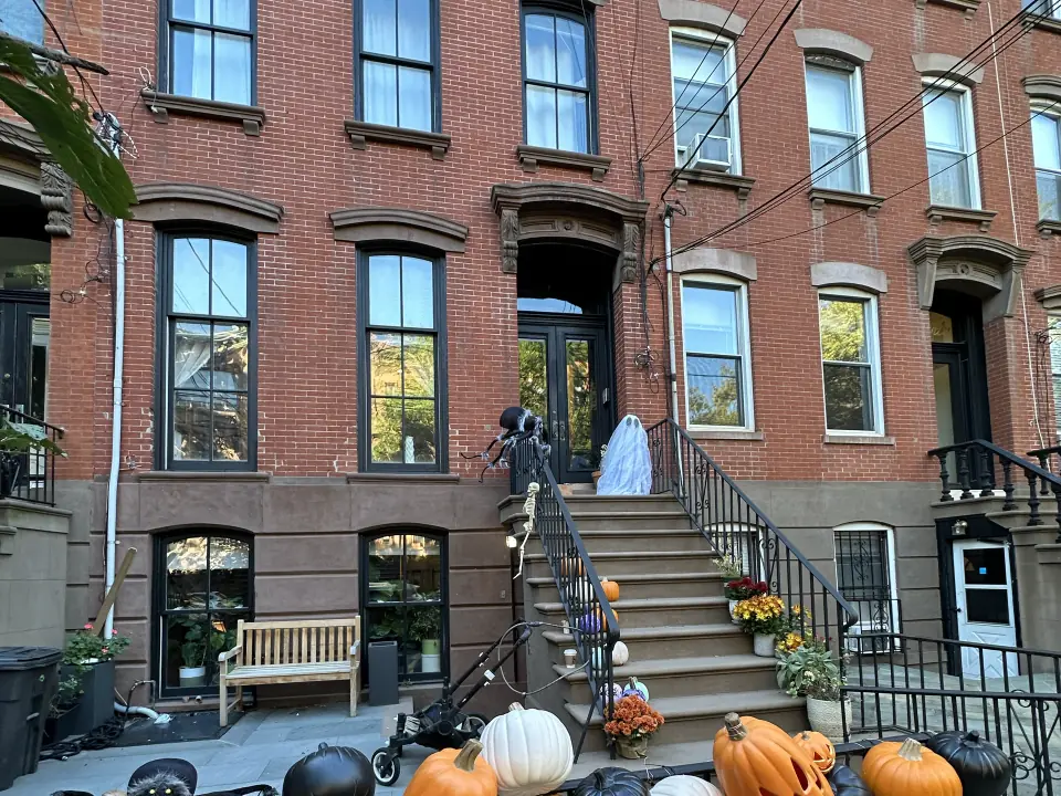 Brick row houses in Hoboken with brownstone bases, tall double-hung windows and a stoop leading to the parlour-floor entrance